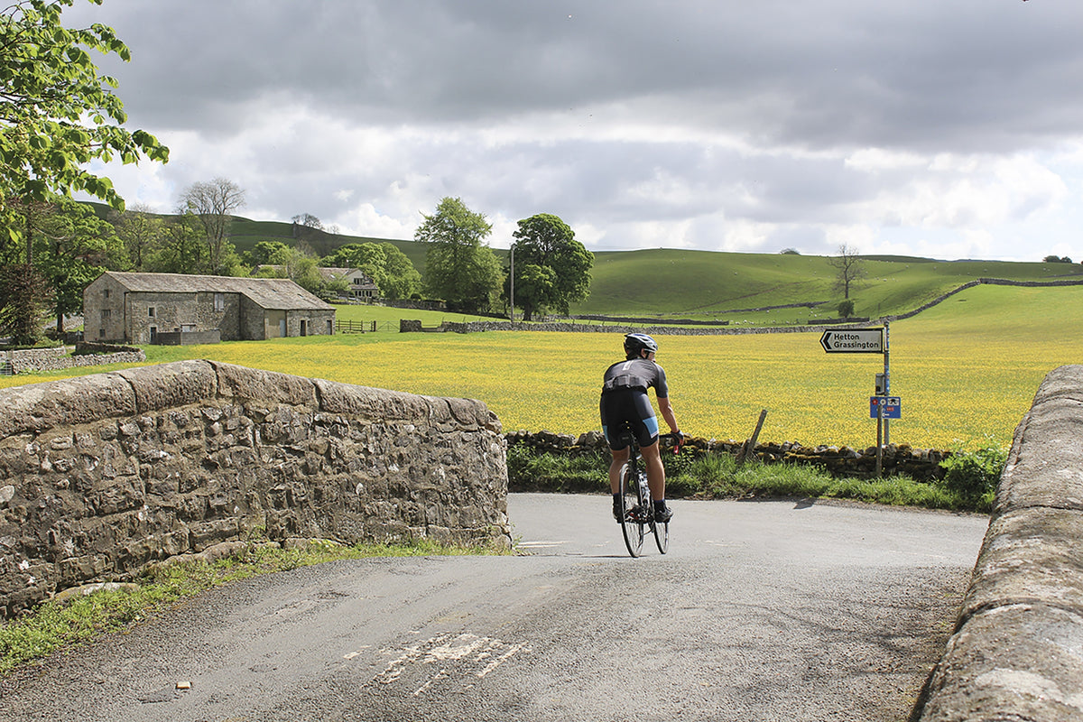 Cycling the Way of the Roses - Route Photos - Crossing Winterburn bridge in front of a sea of buttercups (Day 1)