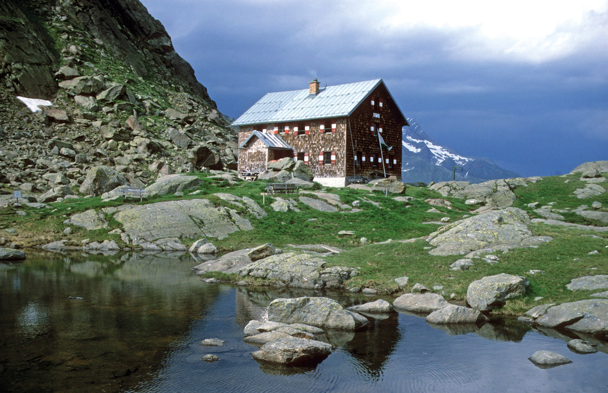 The Mountain Hut Book - Route Photos - Overlooking a tiny lake, the shingle-walled  Bremer Hut belongs to the Bremen Section of the German Alpine Club