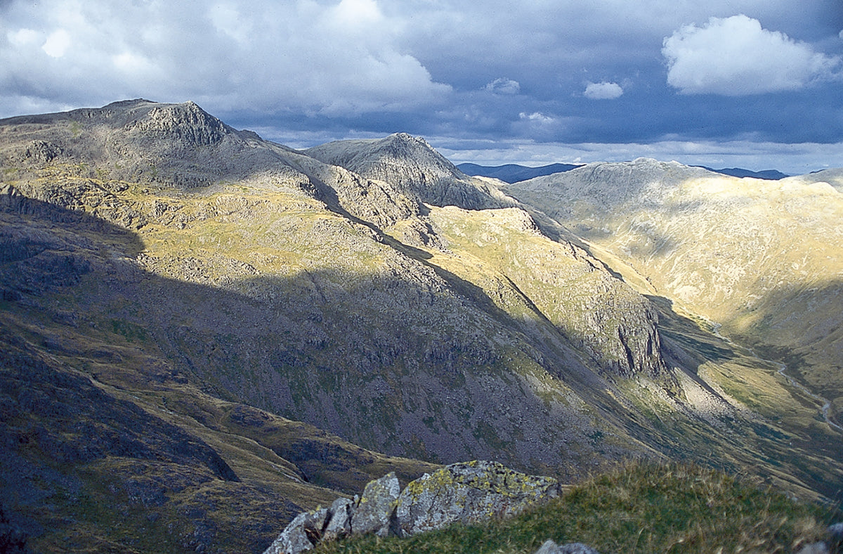 Walking the Lake District Fells - Borrowdale - Route Photos - Sunlight and shadow across the eastern cliffs of Scafell Pike from the ridge of Scafell above Foxes Tarn