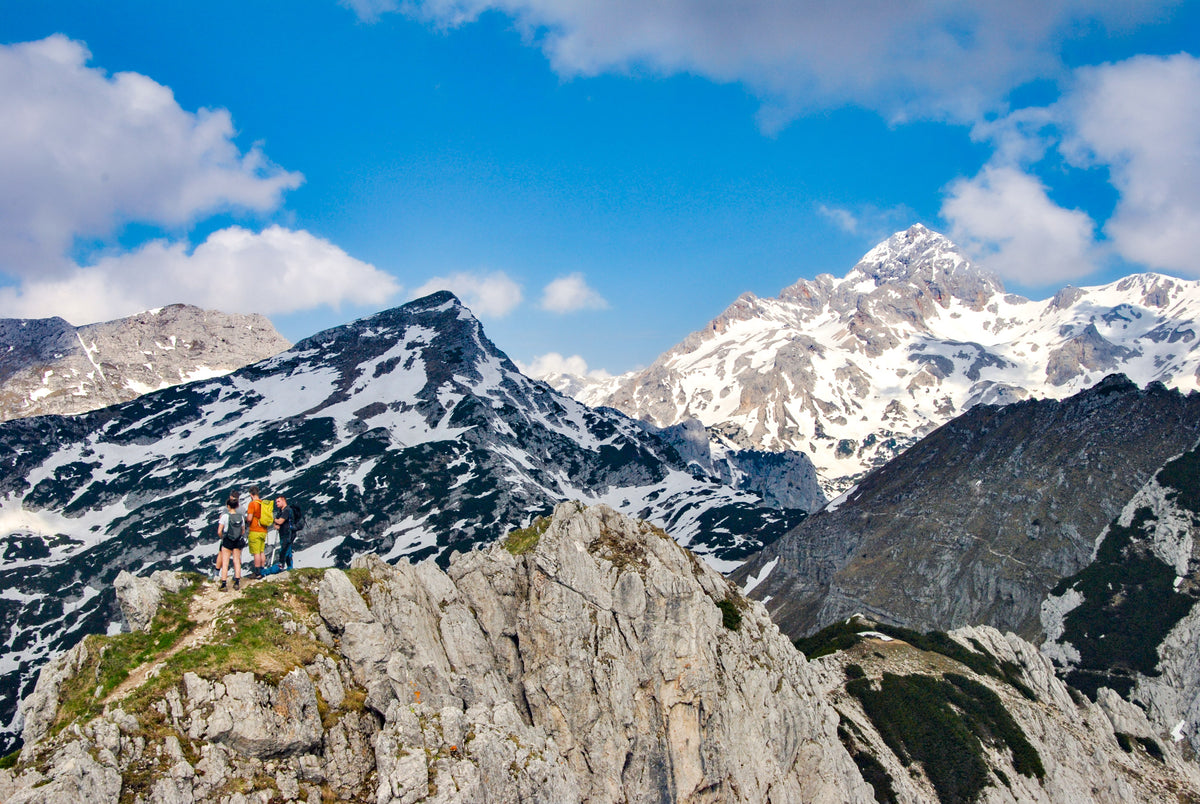 Walking the Julian Alps of Slovenia - Route Photos - Hikers on the summit of Viševnik with Triglav high in the background